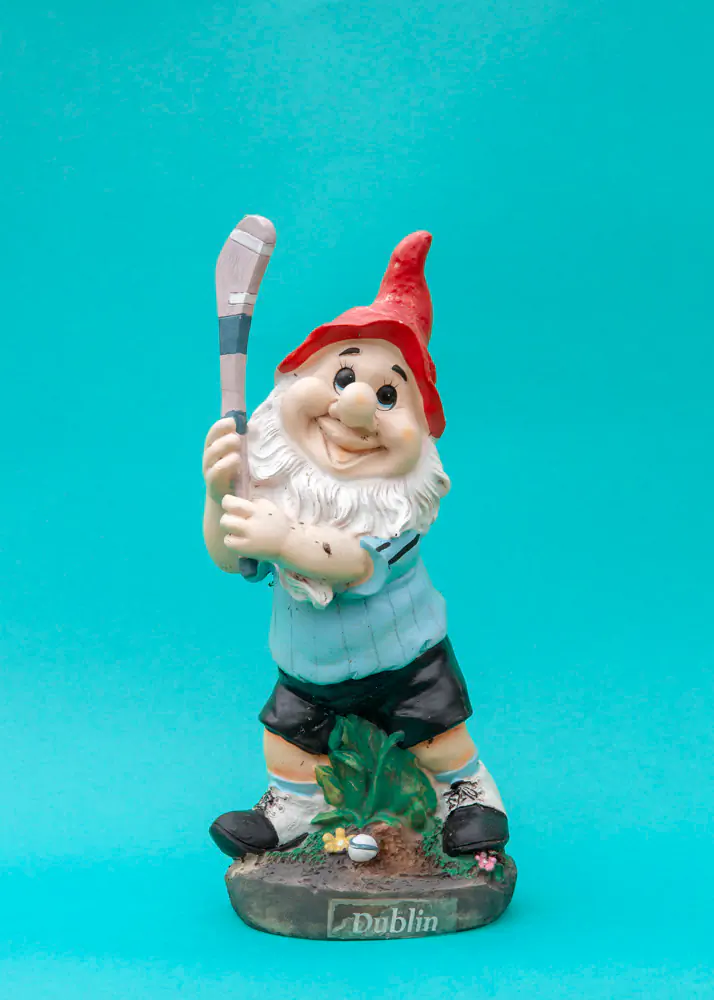 Garden gnome with GAA hurley and Dublin jersey against a teal background